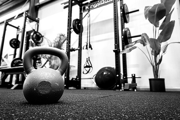 Een zwart-witfoto van een kettlebell in een fitnessruimte